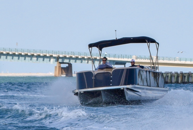 Tritoon cruising by the bridge